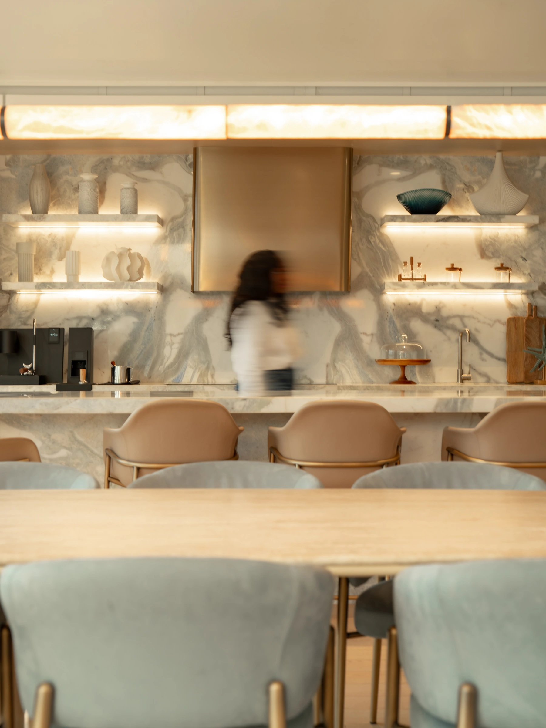 An illuminated marble kitchen with upholstered bar seating