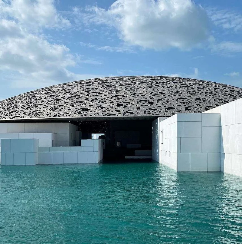 Louvre Abu Dhabi beside turquoise water